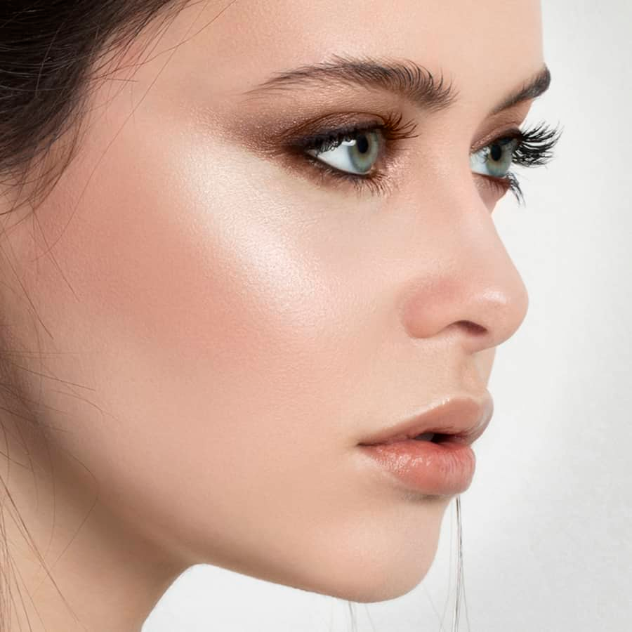 A woman using highlighter to create a natural glow