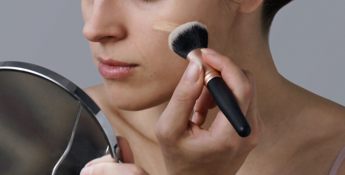 A woman applying tinted moisturizer to her face